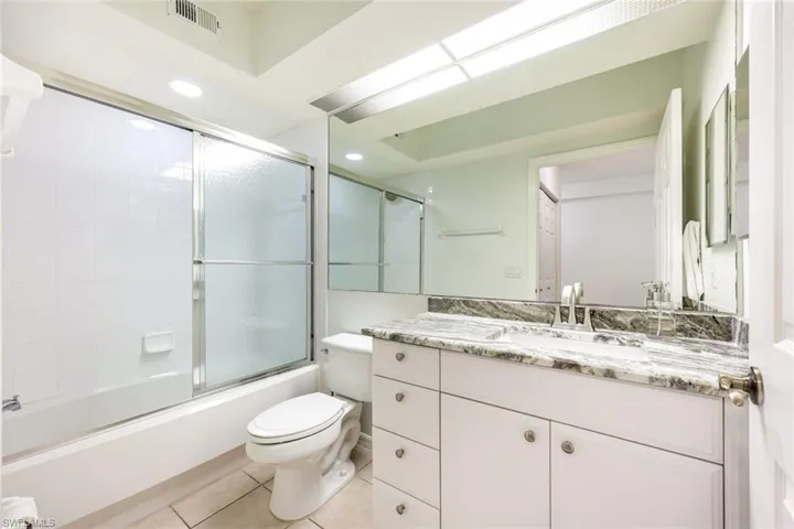 Guest bathroom with tub/shower combination, granite countertop and plenty of storage space.