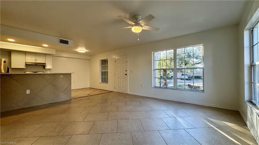 Unfurnished living room with ceiling fan and light tile patterned floors