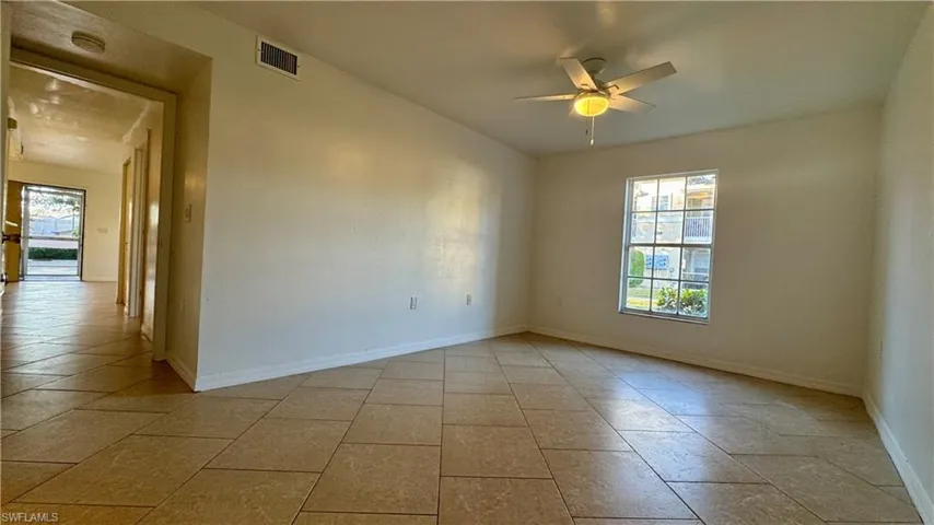 Empty room featuring plenty of natural light, ceiling fan, and light tile patterned floors