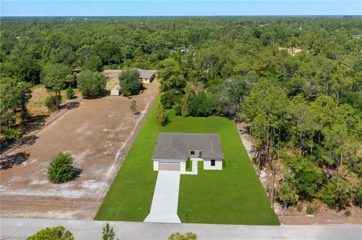 Birds eye view of property with a view of trees