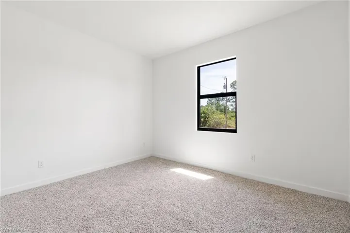 Empty room with carpet and baseboards