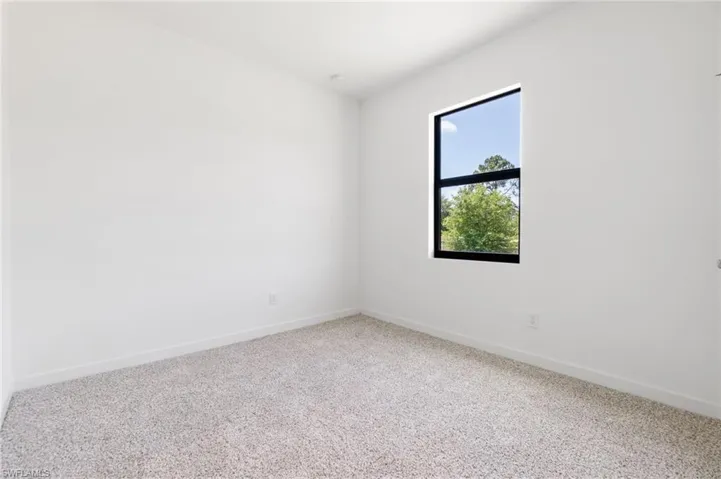 Empty room with carpet flooring and baseboards