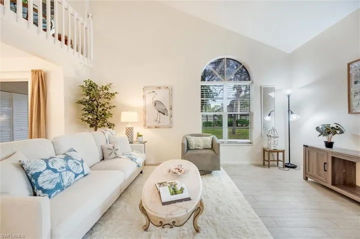 Living room featuring high vaulted ceiling and wood finish floors