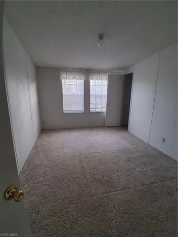 Carpeted empty room with a textured ceiling