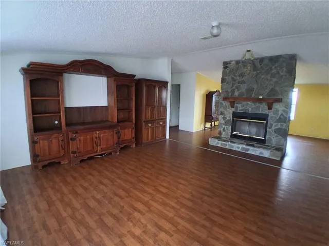 Living area with a fireplace and dark wood-style flooring