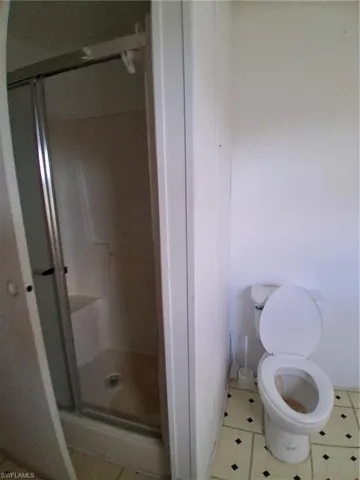 Bathroom featuring a shower stall and tile patterned floors