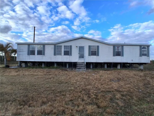 Manufactured / mobile home featuring entry steps and a front yard