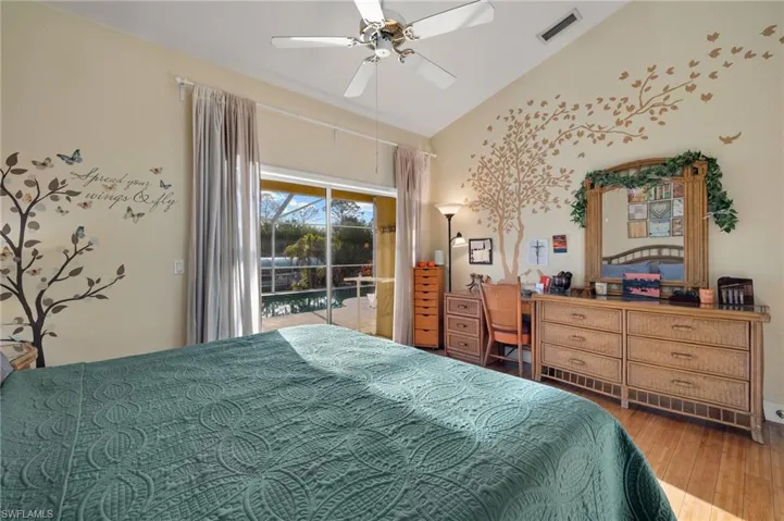 Bedroom with access to exterior, hardwood / wood-style floors, vaulted ceiling, and ceiling fan