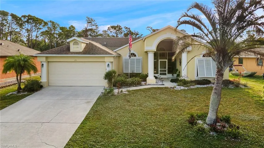 Ranch-style house featuring a garage and a front yard