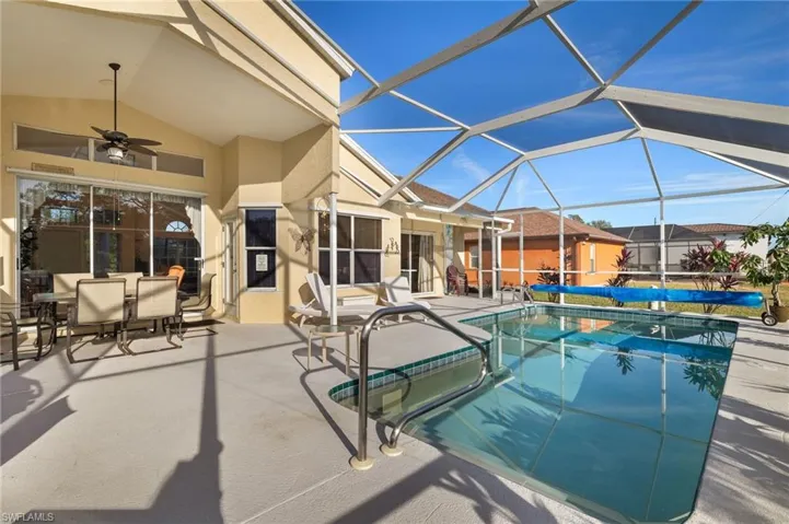 View of swimming pool featuring a patio area, ceiling fan, and a lanai