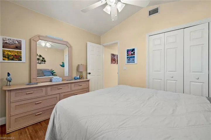 Bedroom featuring hardwood / wood-style flooring, ceiling fan, lofted ceiling, and a closet
