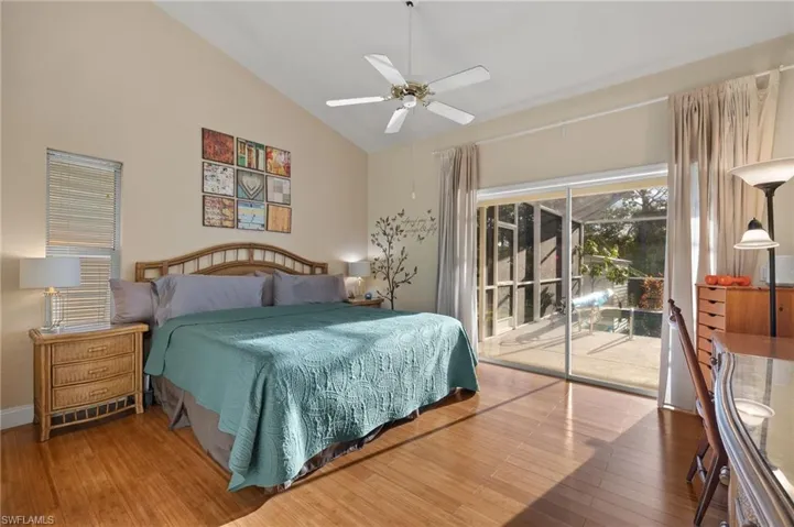 Bedroom with wood-type flooring, access to outside, high vaulted ceiling, and ceiling fan