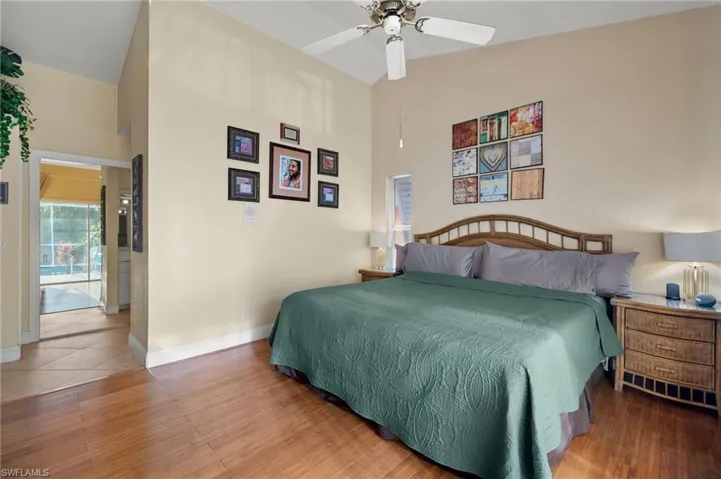 Bedroom featuring ceiling fan, wood-type flooring, and high vaulted ceiling