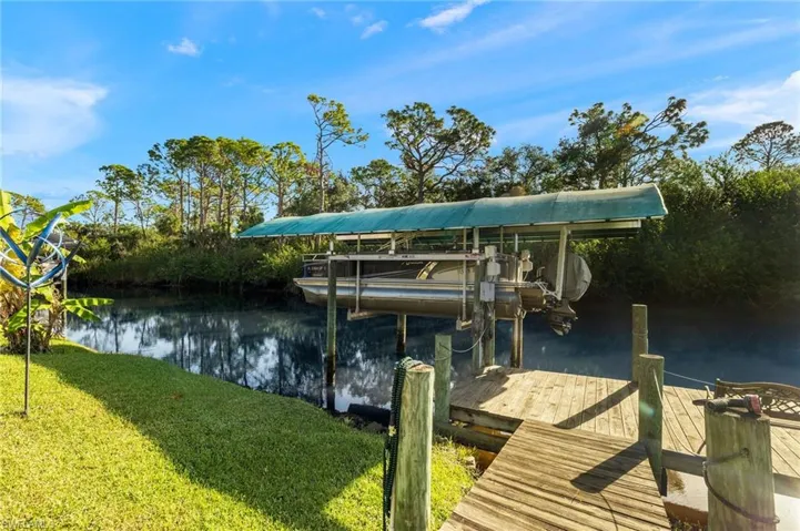 View of dock with a water view and a lawn
