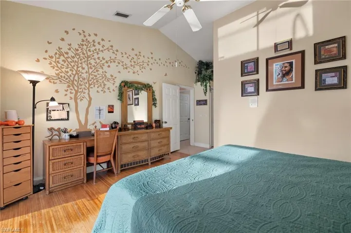 Bedroom with ceiling fan, vaulted ceiling, and light wood-type flooring
