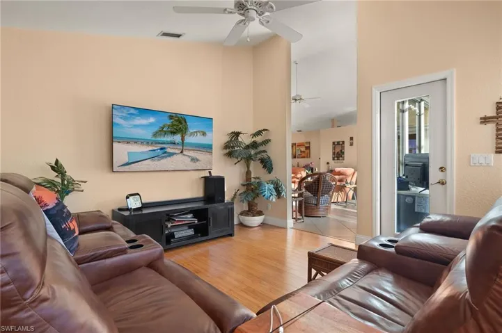 Living room with ceiling fan and light hardwood / wood-style floors