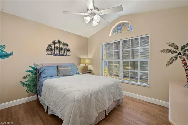 Bedroom featuring ceiling fan, wood-type flooring, and lofted ceiling