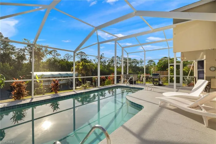 View of swimming pool featuring glass enclosure and a patio area