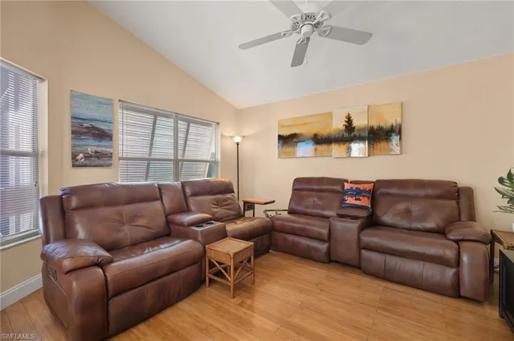 Living room featuring ceiling fan, light hardwood / wood-style floors, a wealth of natural light, and vaulted ceiling