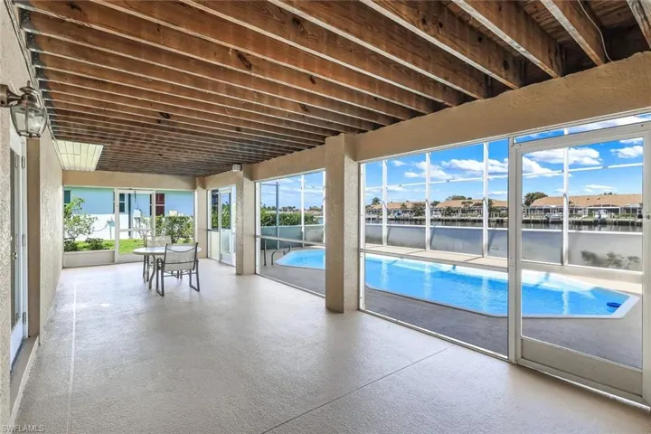 Outdoor pool with a water view, outdoor dining area, and a patio area