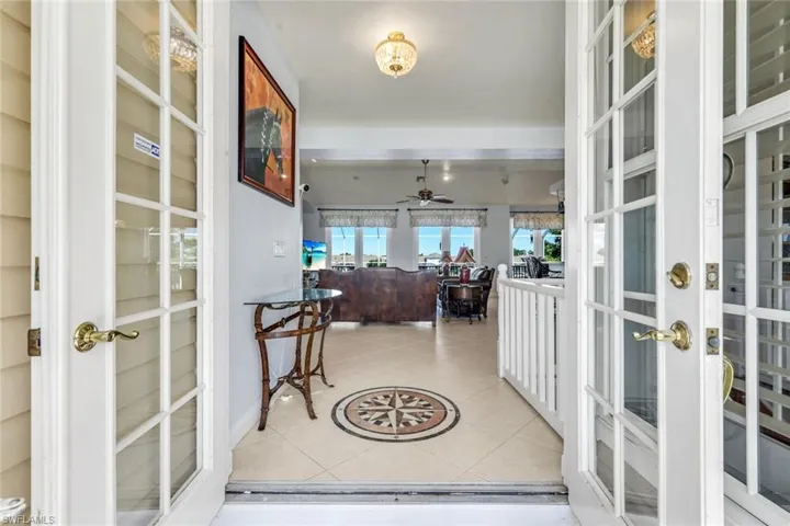 Foyer entrance featuring light tile patterned floors, ceiling fan, and french doors