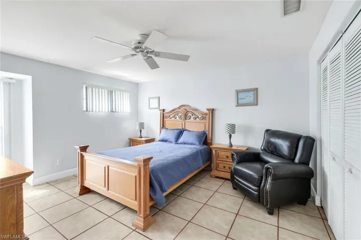 Bedroom featuring a closet, ceiling fan, and light tile patterned floors