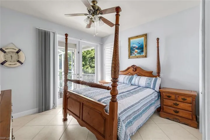 Bedroom featuring access to exterior, a ceiling fan, and light tile patterned floors