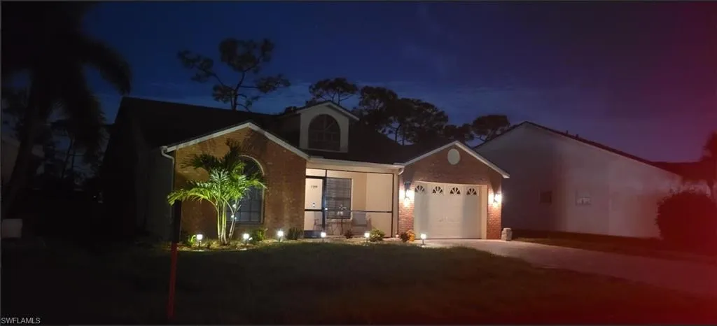 View of front of house, Brick an attached garage, and driveway