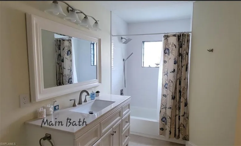 Bathroom with vanity and shower / bathtub combination with curtain