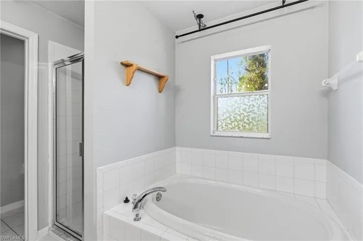 Full bathroom with a garden tub and a shower stall