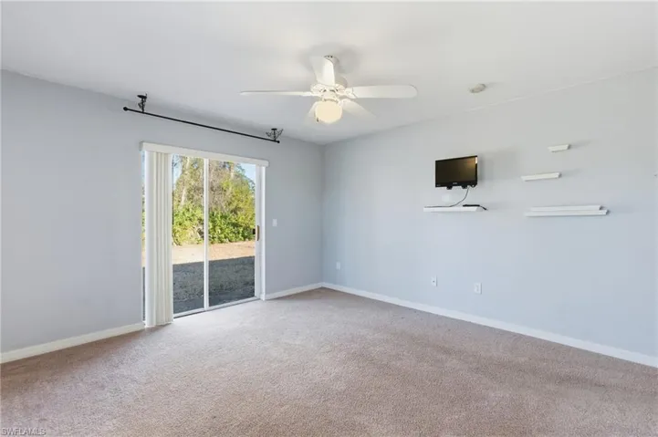 Unfurnished room featuring light carpet and ceiling fan