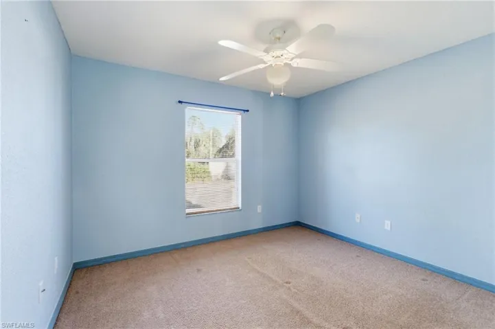 Empty room featuring carpet floors and a ceiling fan
