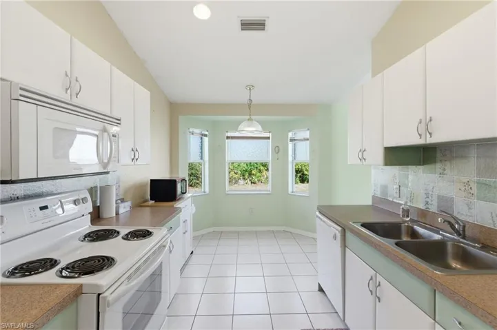 Kitchen with white appliances and white cabinetry