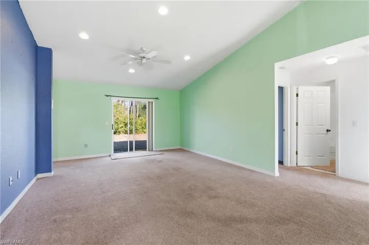 Empty room with lofted ceiling, a ceiling fan, light colored carpet, and recessed lighting
