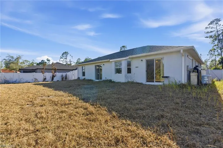 Back of property with a fenced backyard, stucco siding, a gate, and roof with shingles