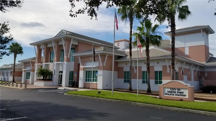 Modern administrative building featuring a prominent entrance with large columns, a light-colored exterior finish, and a multi-level roofline