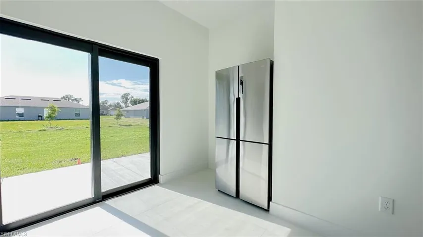 Kitchen with freestanding refrigerator and baseboards