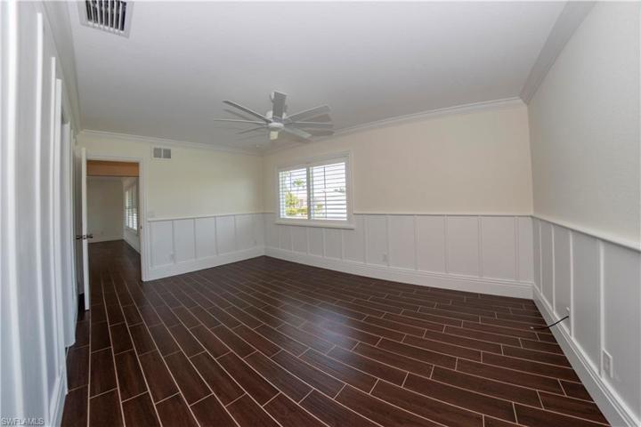 Large Primary Bedroom with Plantation Shutters and custom paneling throughout.
