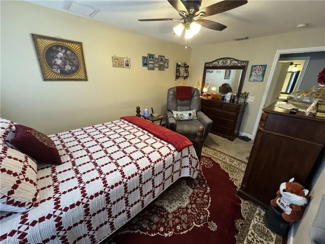 Carpeted bedroom with a ceiling fan