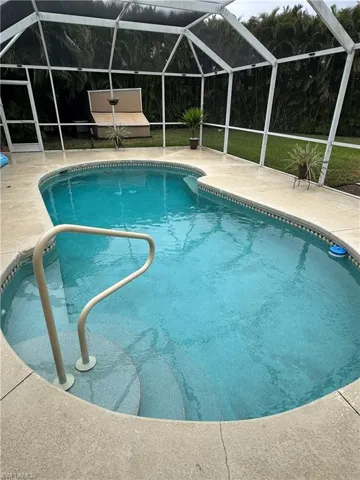 Swimming pool with a lanai, a sunroom, and a patio area