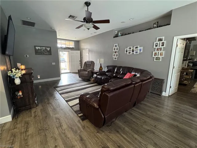 Living room with dark wood finished floors and ceiling fan
