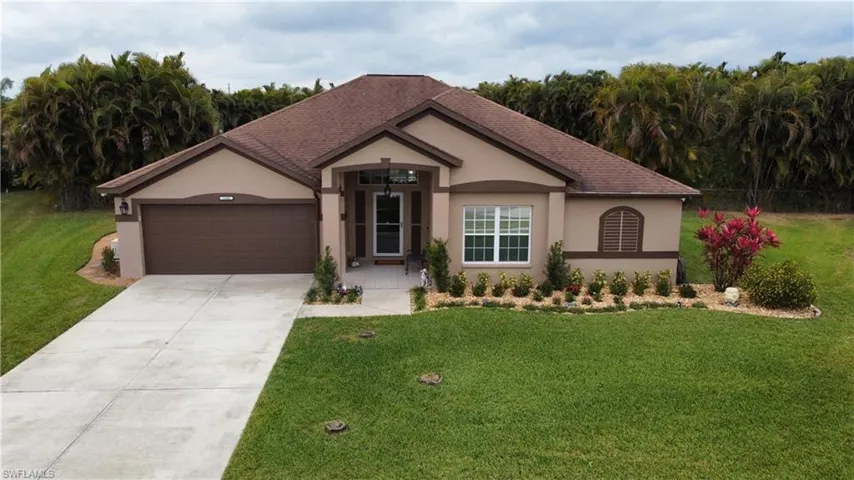 Single story home with a front lawn, a garage, concrete driveway, stucco siding, and a shingled roof