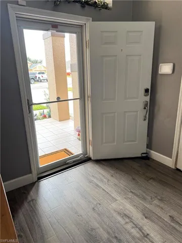 Doorway featuring baseboards and wood finished floors