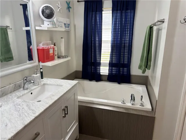 Full bathroom featuring vanity and a garden tub