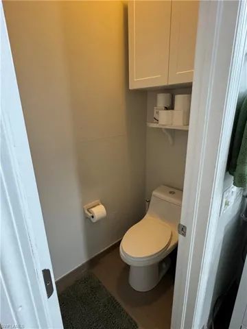Bathroom featuring toilet and dark wood-style floors
