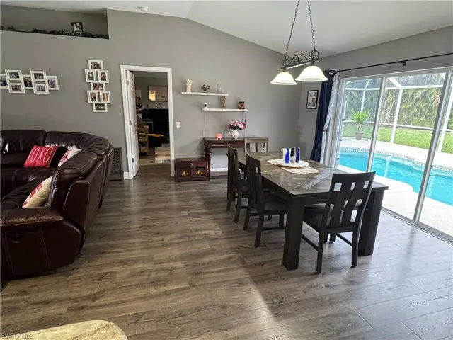 Dining space featuring wood finished floors and vaulted ceiling