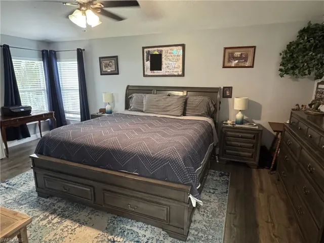 Bedroom with a ceiling fan and dark wood-style floors