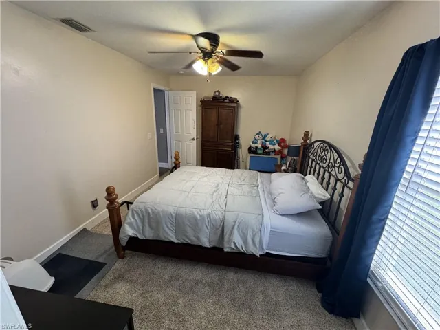 Carpeted bedroom featuring baseboards and ceiling fan