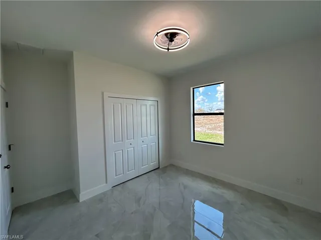 Unfurnished bedroom with a closet and light marble finish floors
