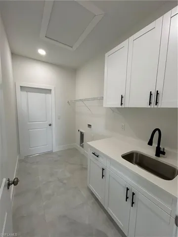 Laundry area featuring hookup for a washing machine, cabinet space, recessed lighting, and concrete floors
